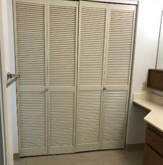 Closet with white doors and white walls.