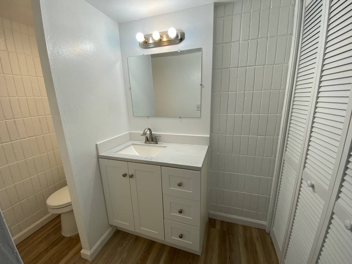 A bathroom with a white sink and a mirror above it.