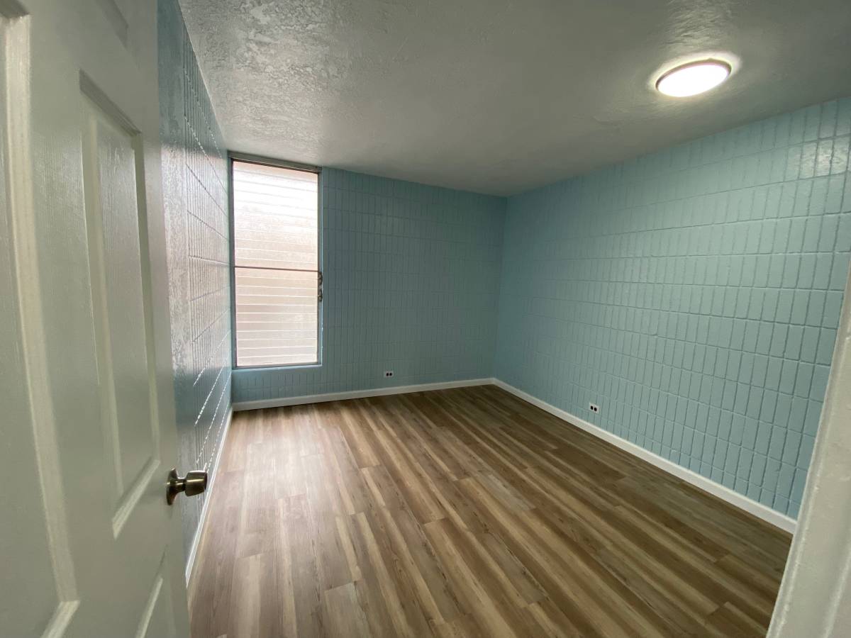 A room with wooden flooring and a white door.