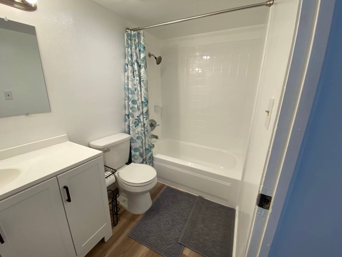 A white toilet sits next to a white sink in a small bathroom.