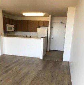 A kitchen with wooden cabinets and a white counter.
