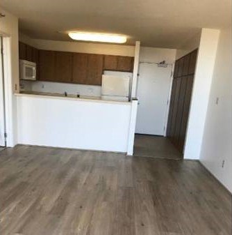 A kitchen with white appliances and wooden cabinets.