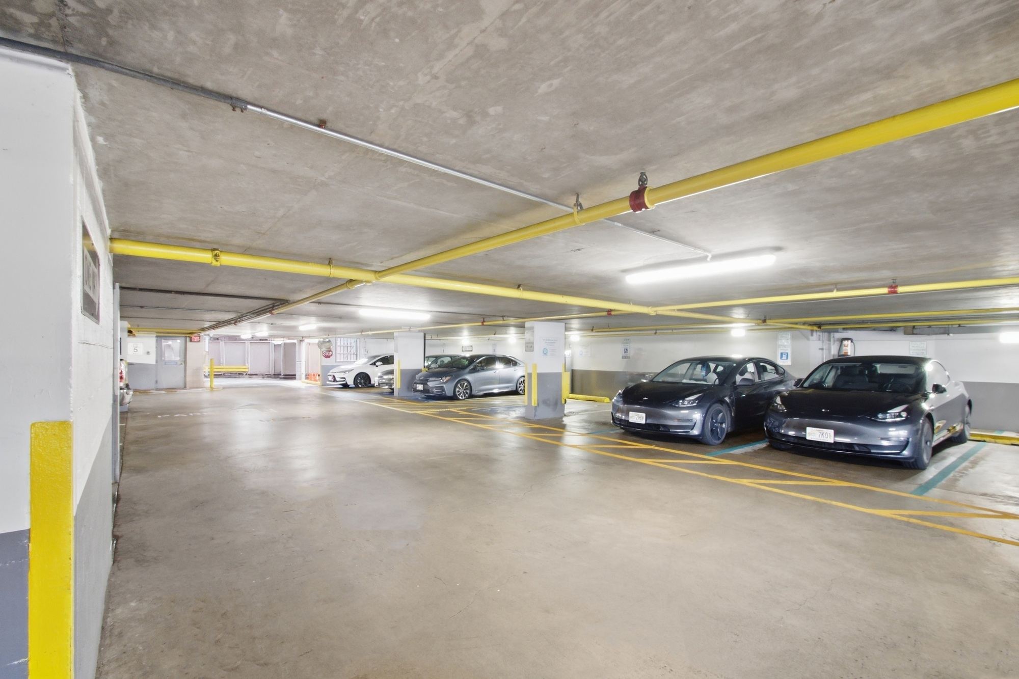 A parking garage with several cars parked in it.