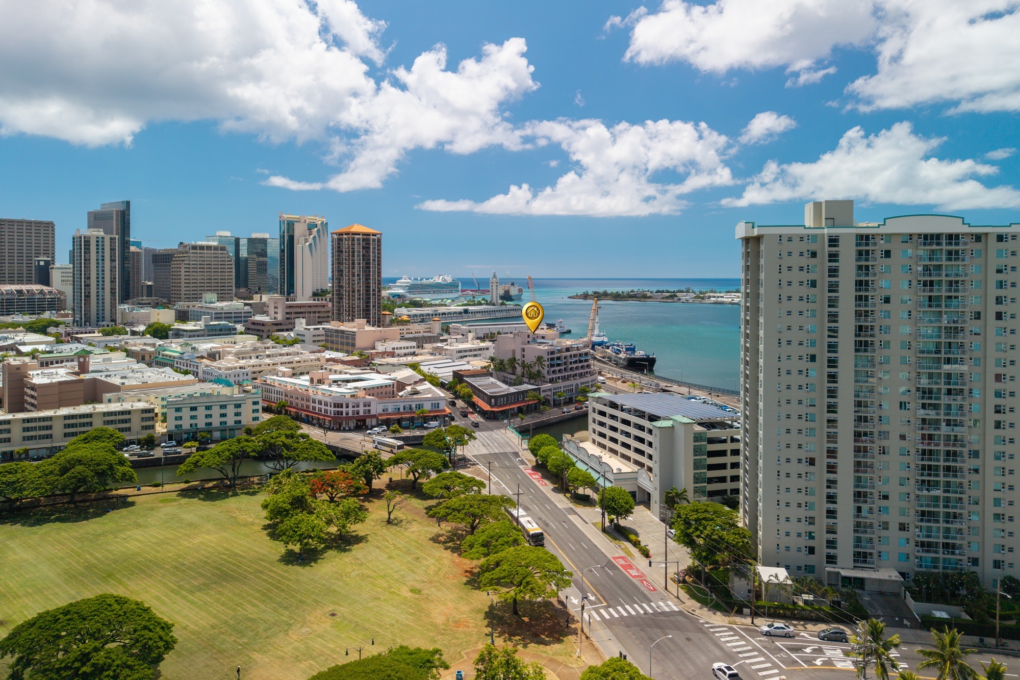 A cityscape with a mix of modern and older buildings, a large body of water, and a clear sky.