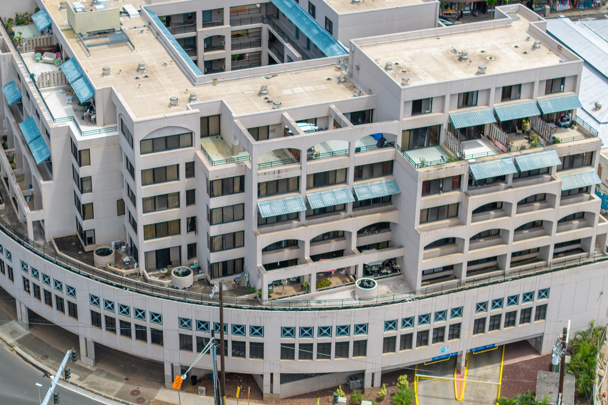 A large white building with blue awnings and balconies.