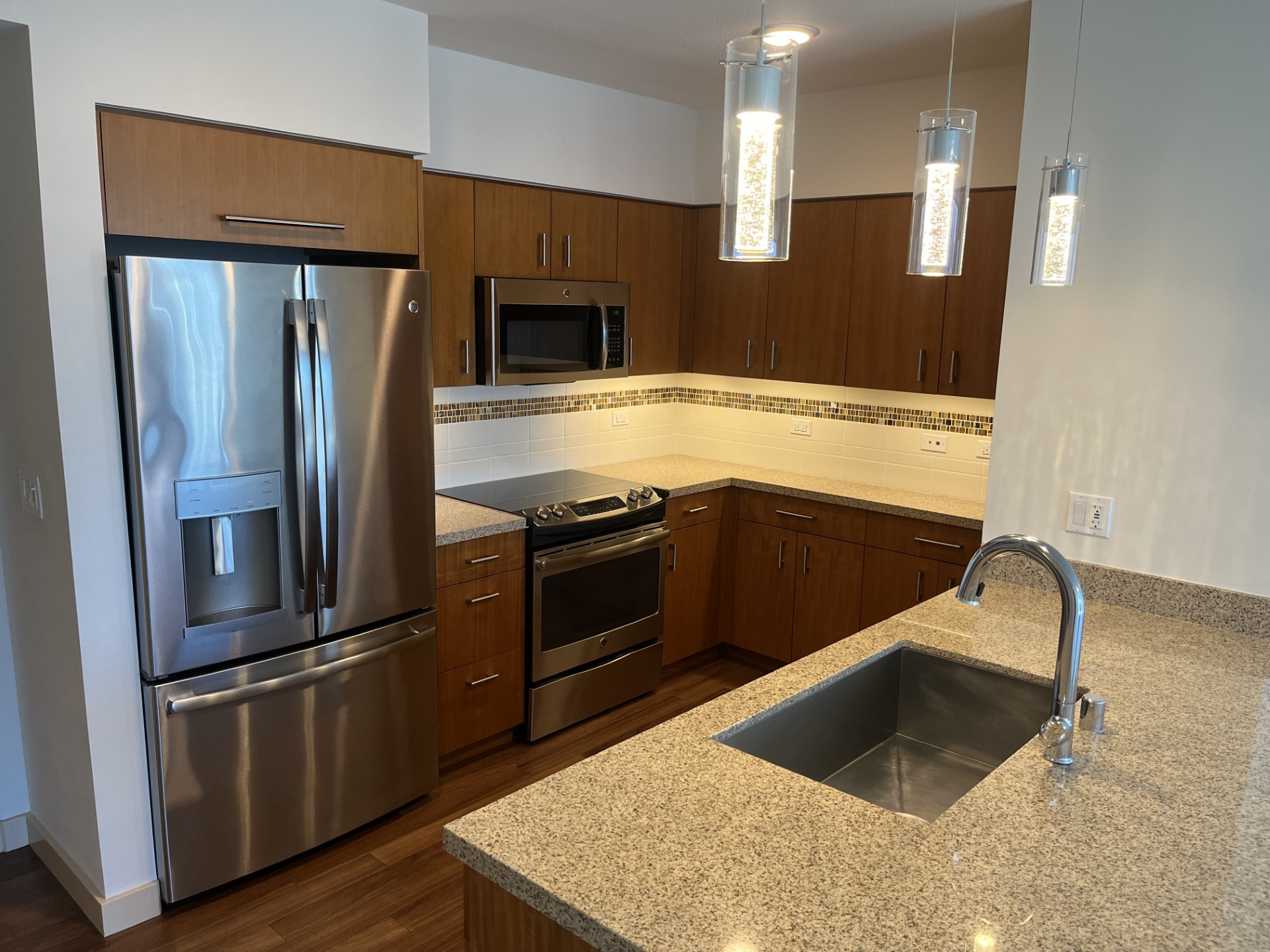 A kitchen with a granite countertop and stainless steel appliances.