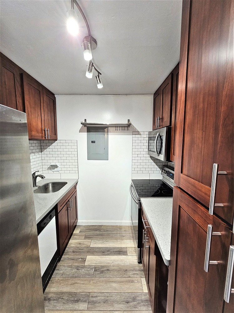 a kitchen with dark wood cabinets and white countertops