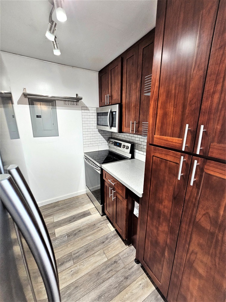 a small kitchen with wooden cabinets and a stainless steel stove