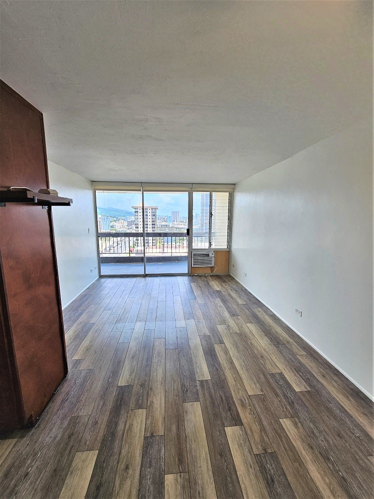 an empty room with hardwood floors and a balcony