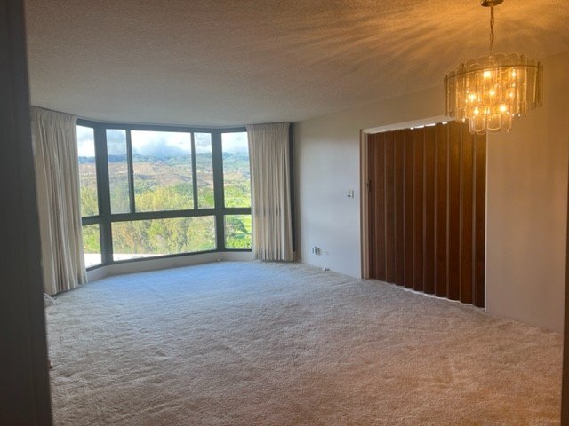 A room with a large window overlooking a landscape.