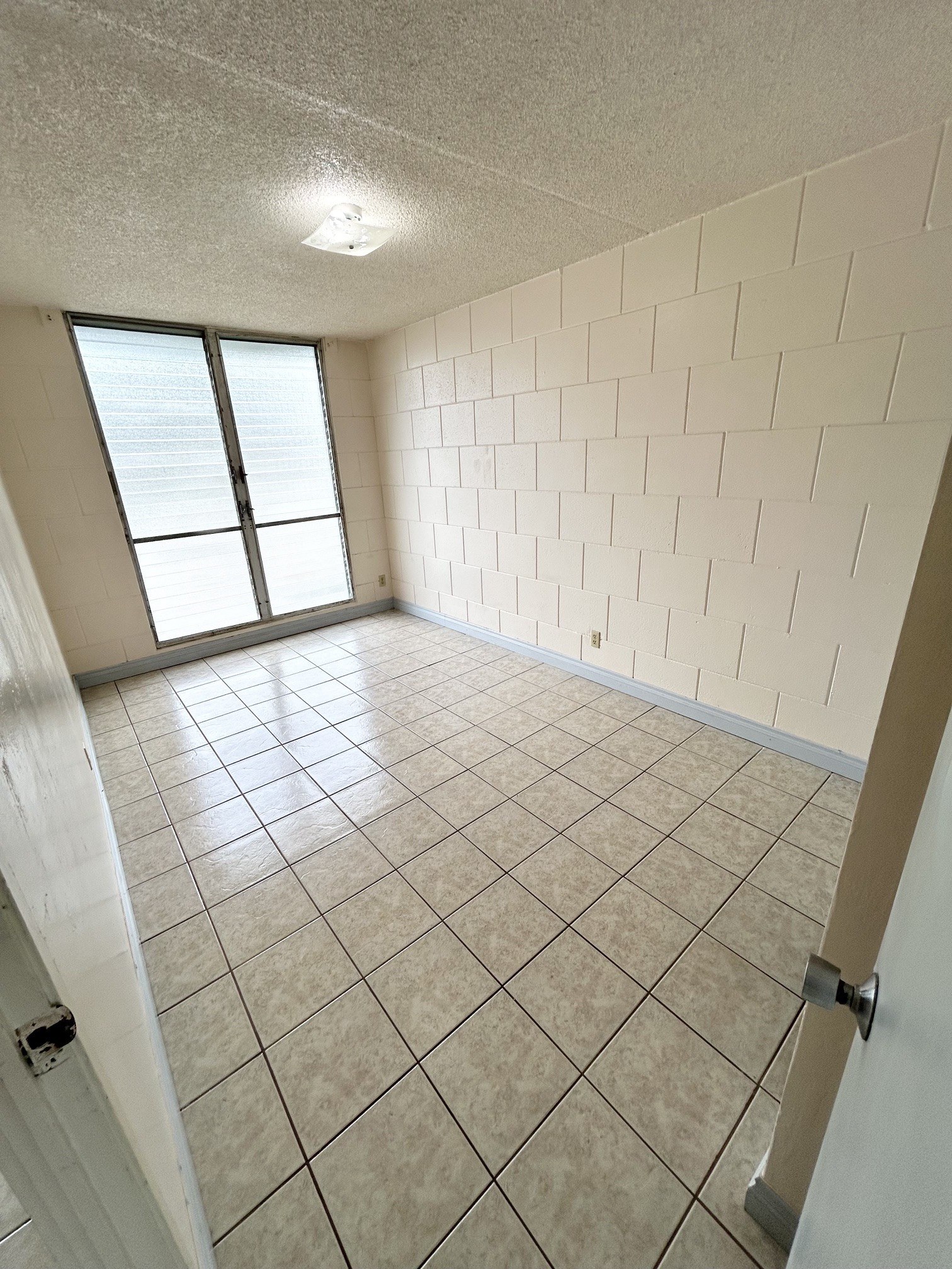 A room with a tiled floor and a window.