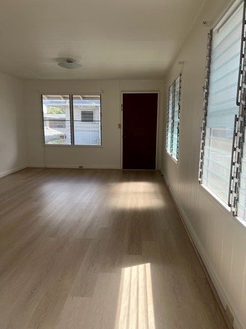 A room with wooden flooring and a window with blinds.