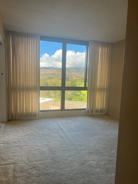 A room with a large window overlooking a landscape.