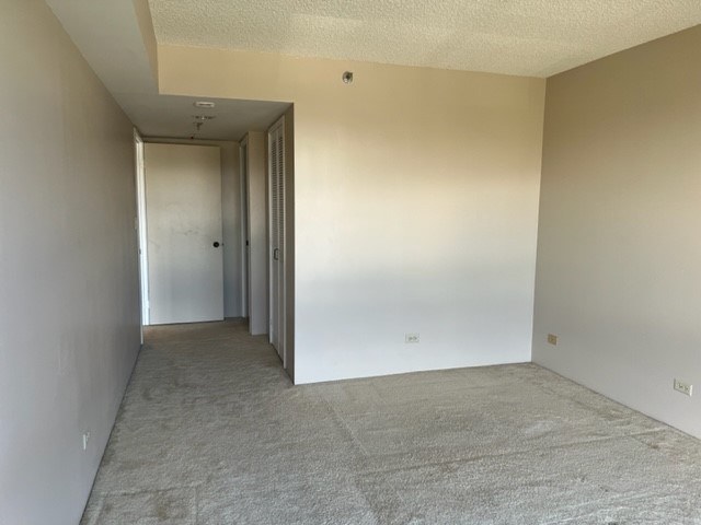 A room with a carpeted floor and white walls.