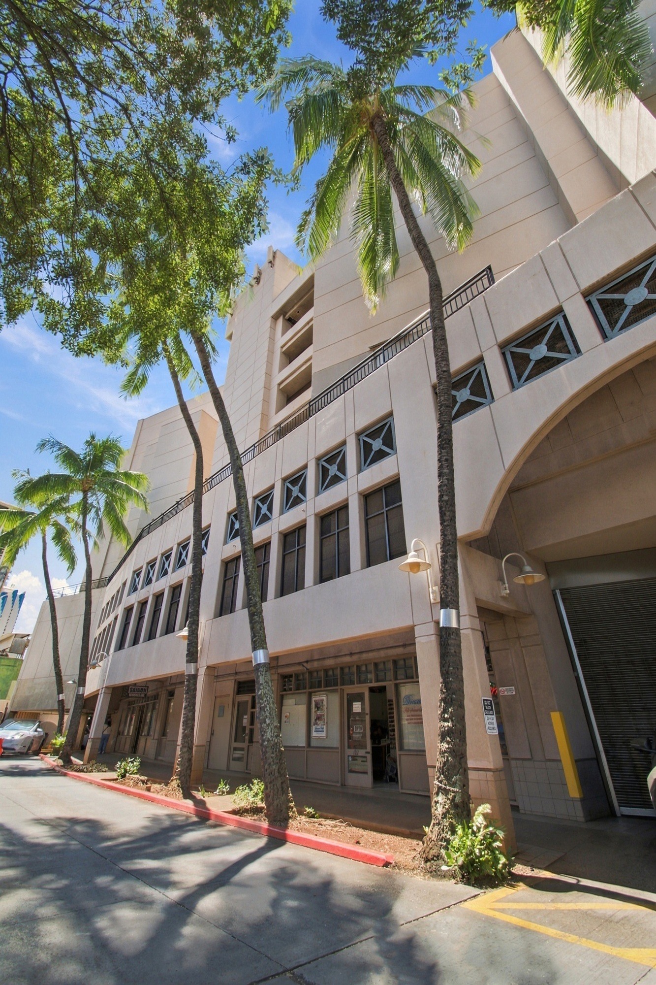 A building with a palm tree in front of it.