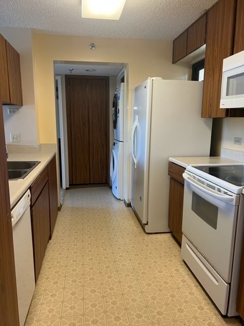 A kitchen with a white refrigerator and white oven.