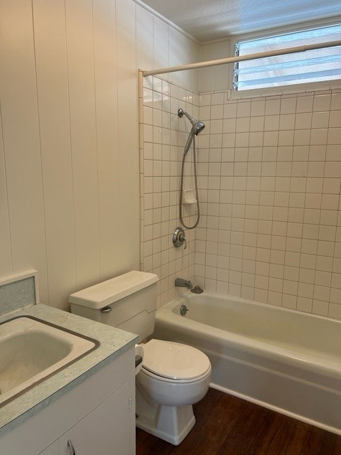 A white toilet sits next to a bathtub in a bathroom.