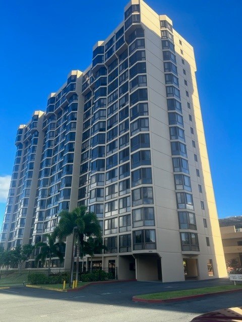 A tall building with many windows and balconies is shown.