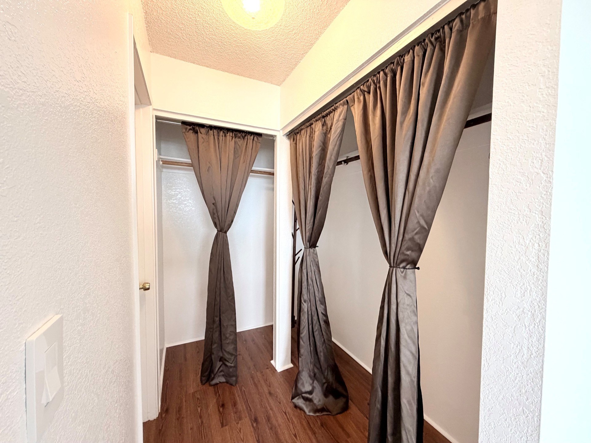 A hallway with a pair of curtains tied in a bow.