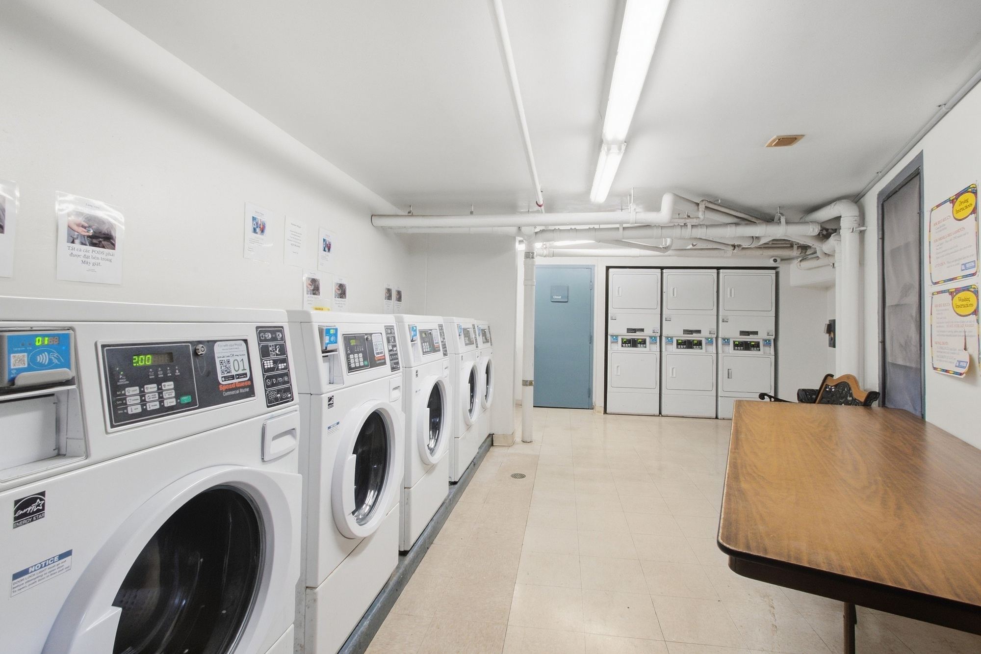 A row of washing machines are lined up in a laundromat.