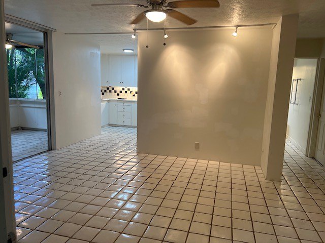 A room with white tiled floors and a ceiling fan.