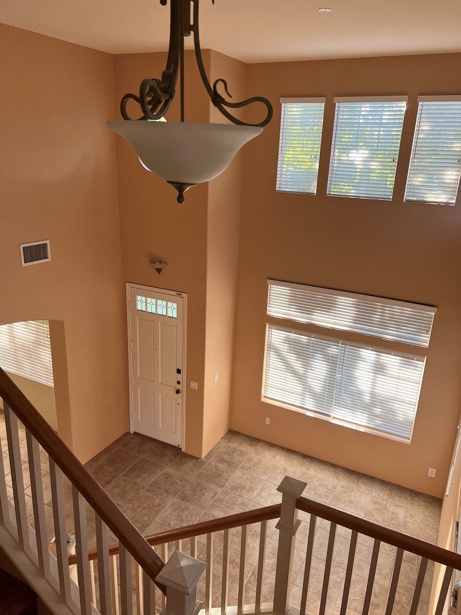 the view from the top of the stairs looking down into theoyer of a house