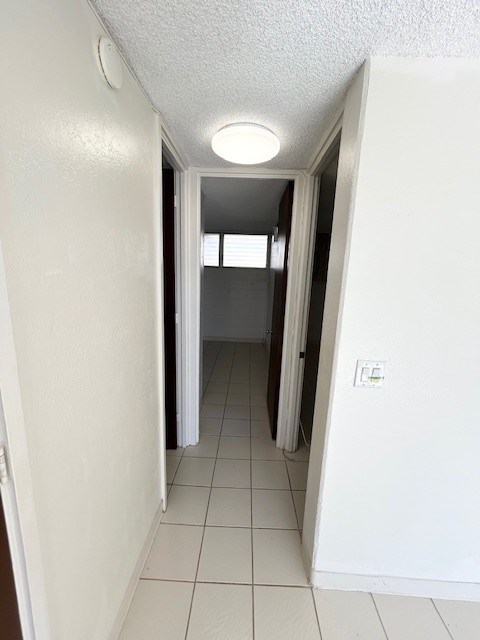 A white hallway with a light on the ceiling.