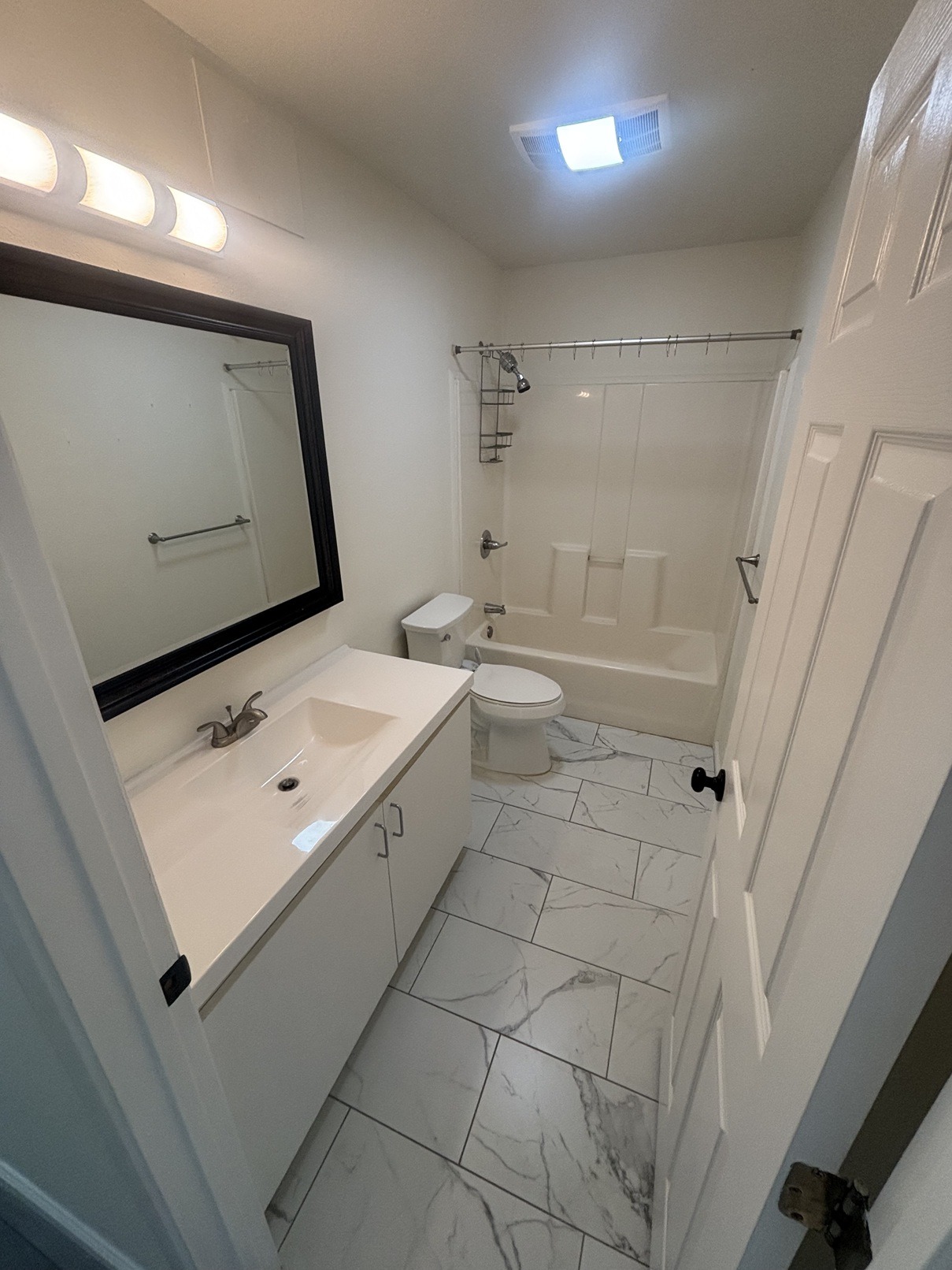 A white bathroom with a sink, toilet, and tub.