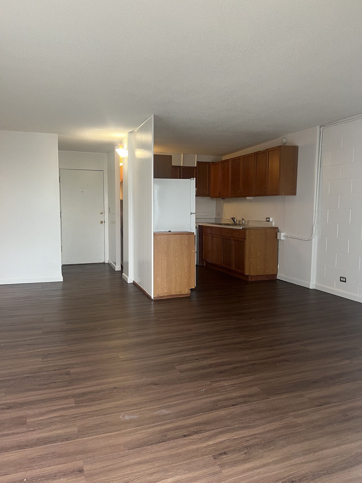A kitchen with wooden floors and white walls.