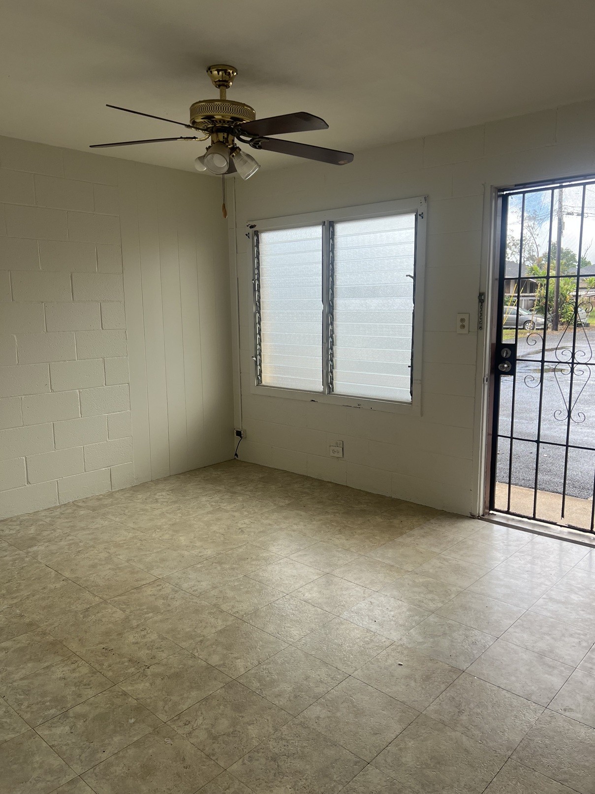 A room with a ceiling fan and a window with blinds.