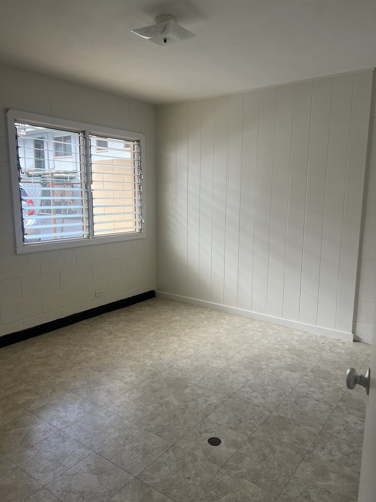 A room with a window and a ceiling fan.