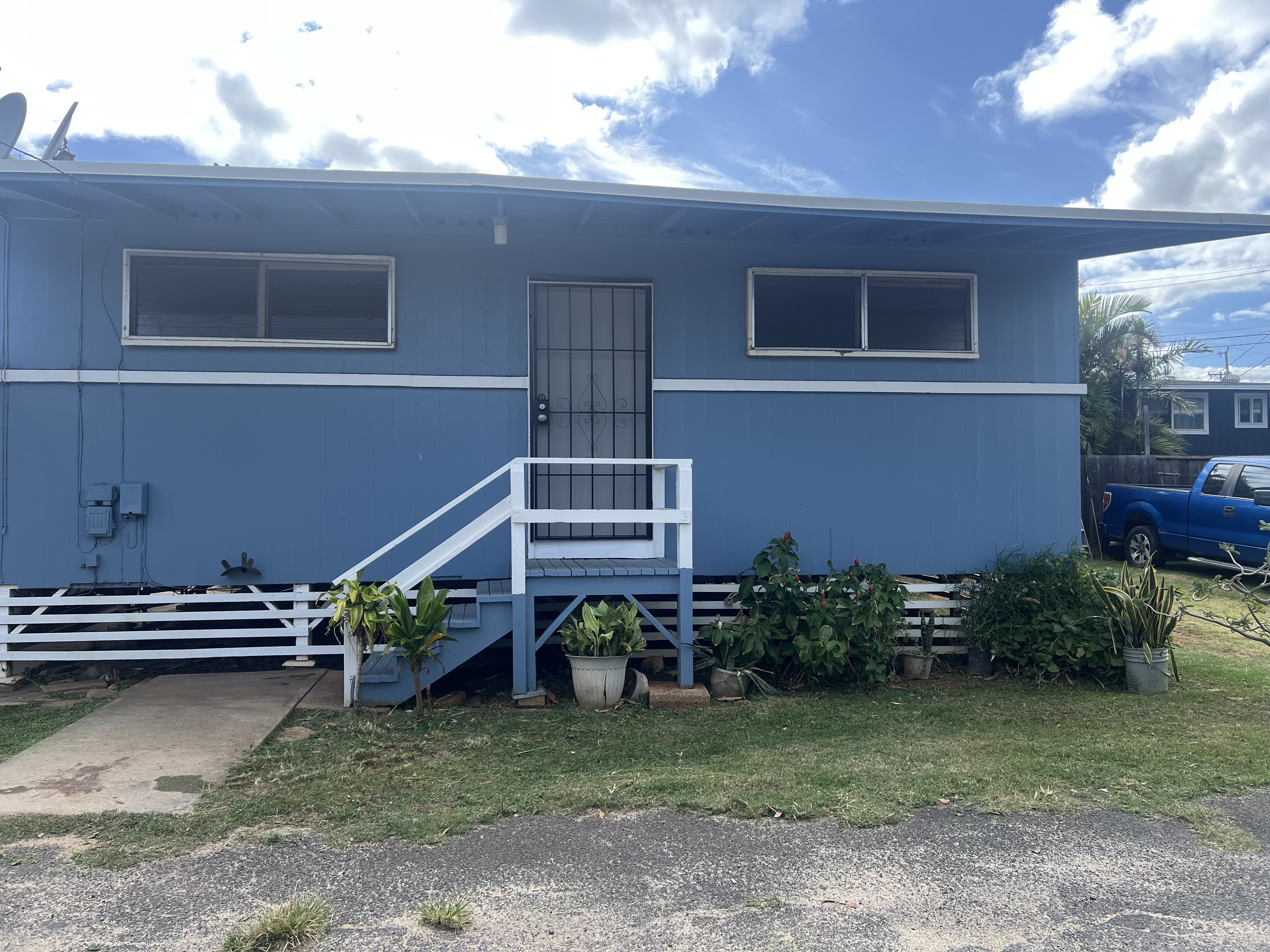A blue house with a white door and windows.