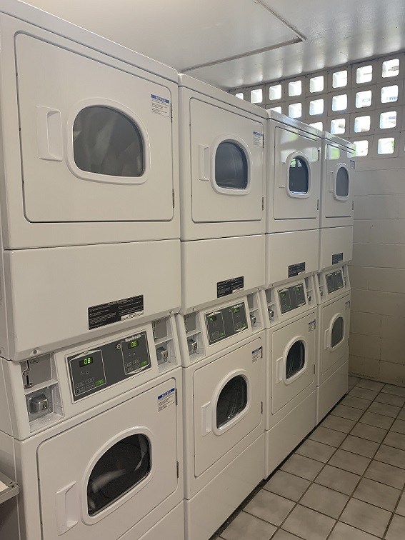 A row of white washing machines in a laundromat.