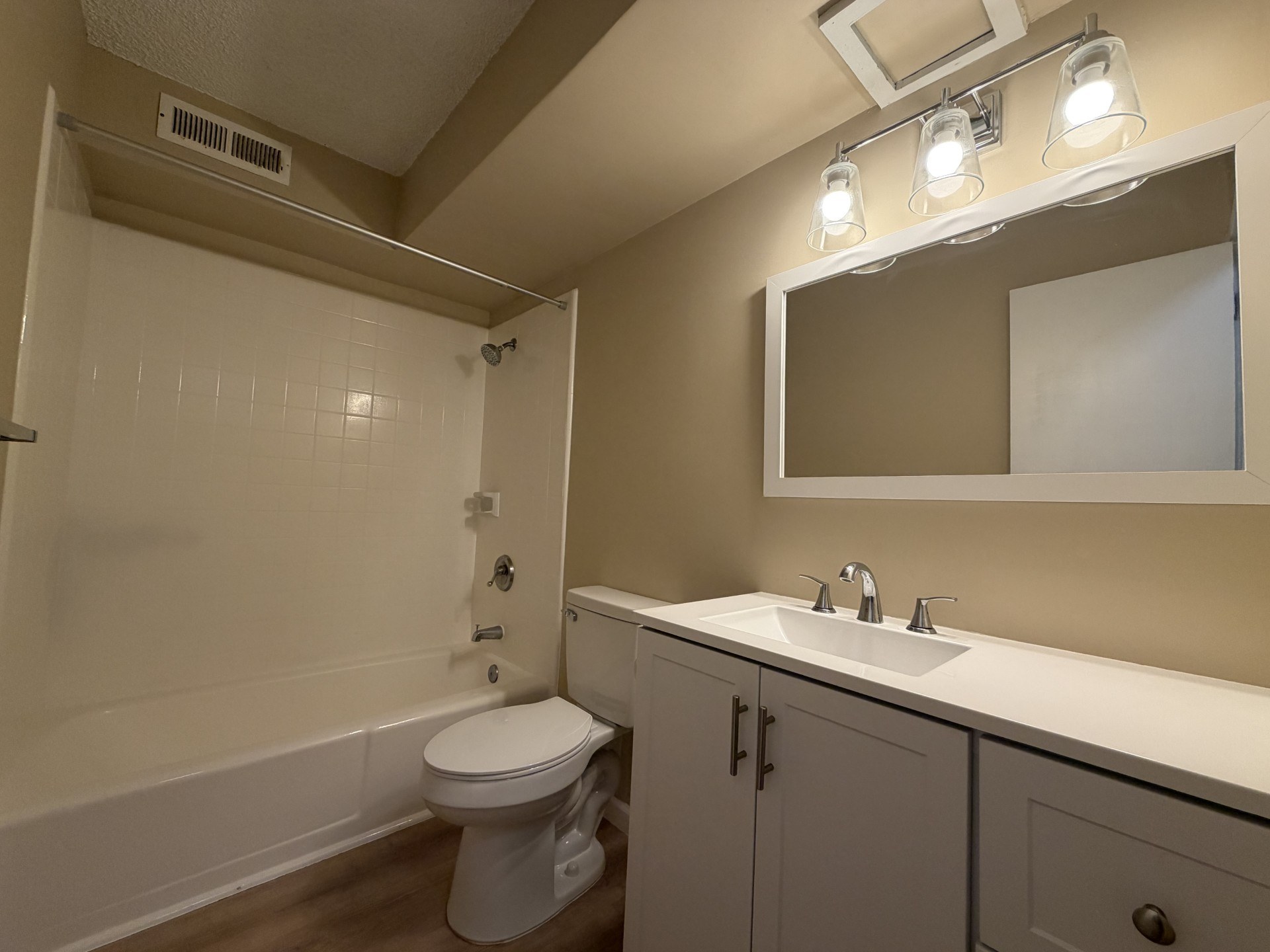 A white toilet sits next to a bathtub in a bathroom.