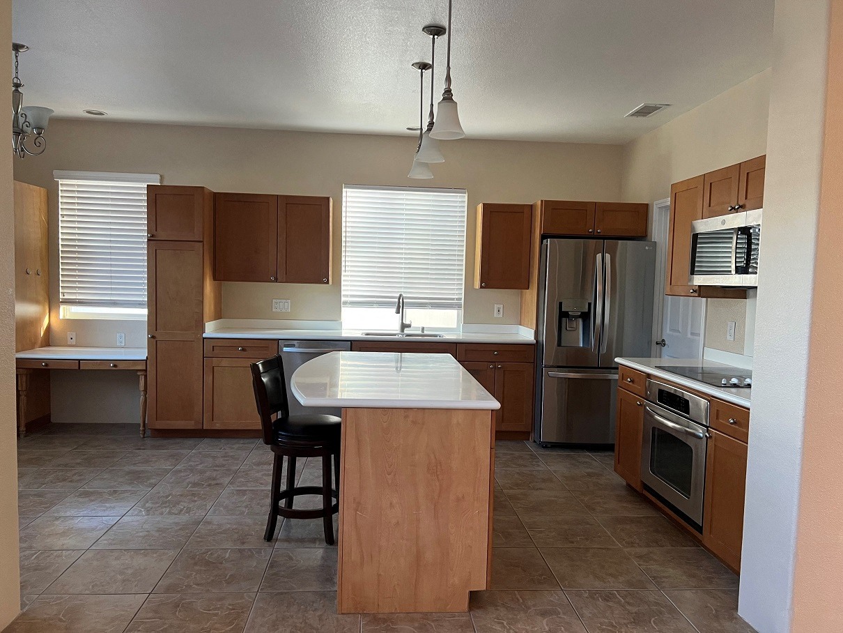 a kitchen with wooden cabinets and stainless steel appliances