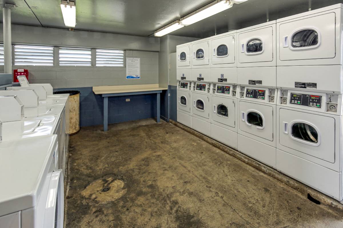 a laundry room with rows of washers and dryers