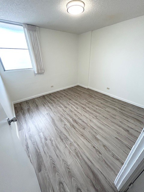 A room with a window and wooden flooring.