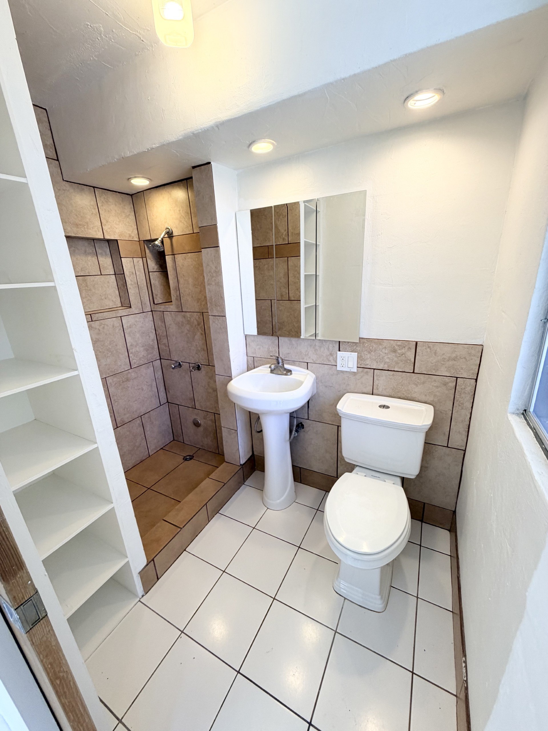 A white toilet and sink in a small bathroom.