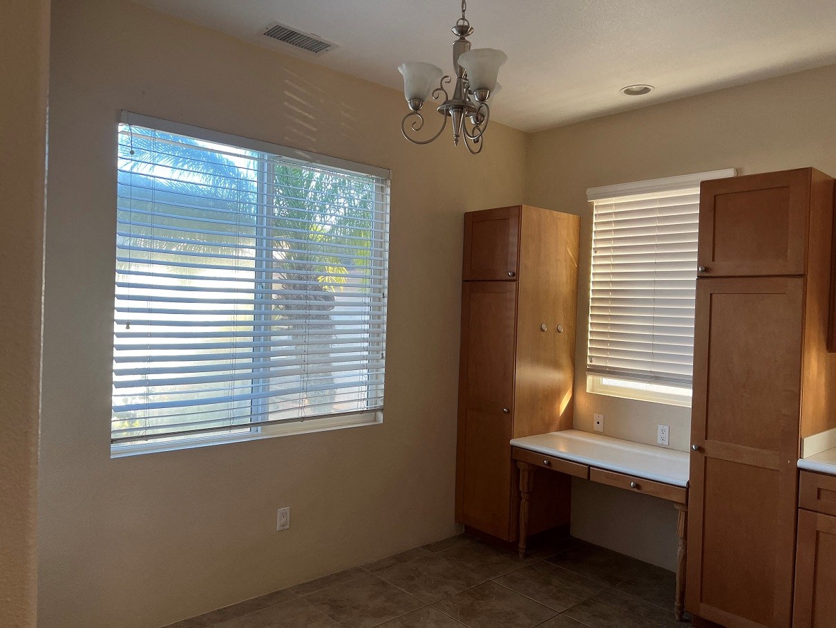a dining room with a large window and wooden tables and chairs