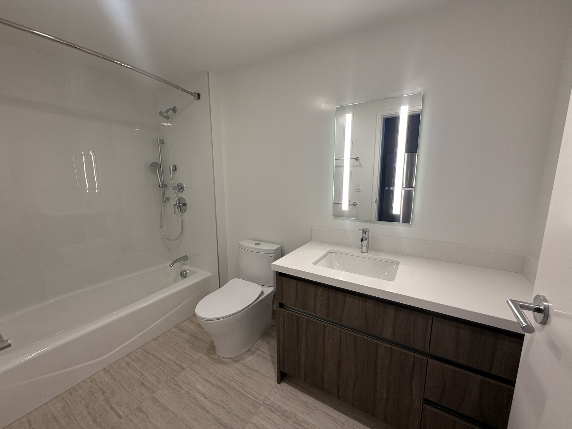 A white bathroom with a toilet, sink, and bathtub.