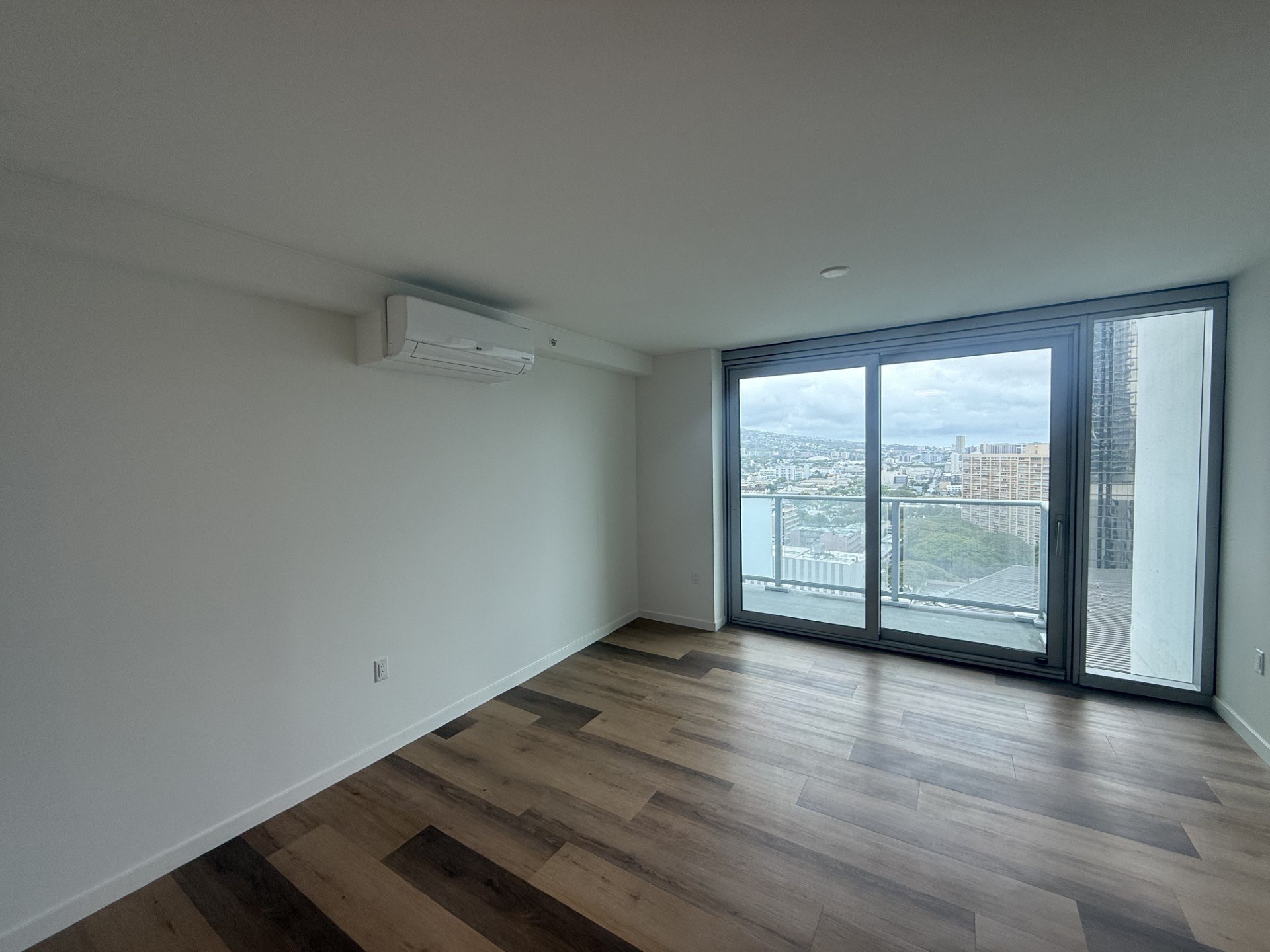 A room with a sliding glass door leading to a balcony.