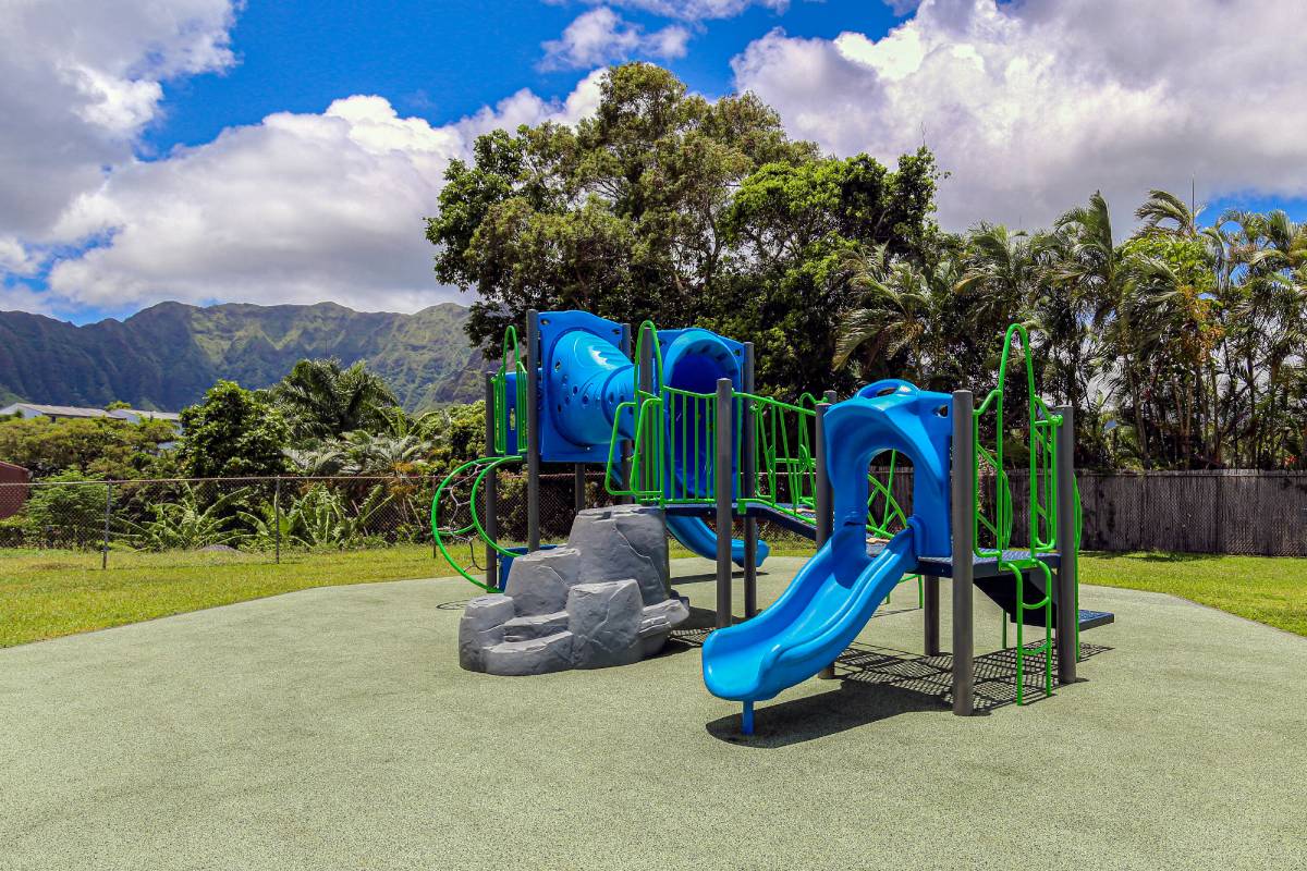 a playground with slides and rocks in a park