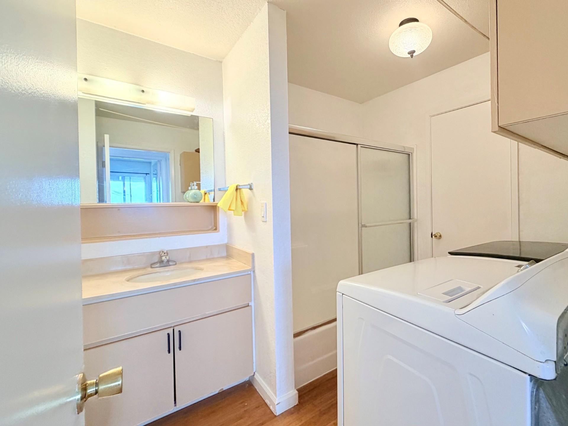 A white washing machine in a small laundry room.
