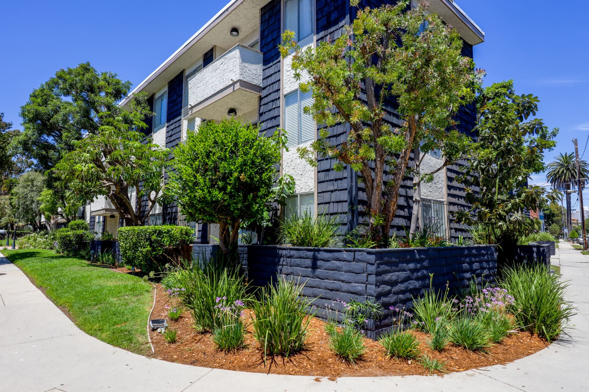 an apartment building with a garden in front of it