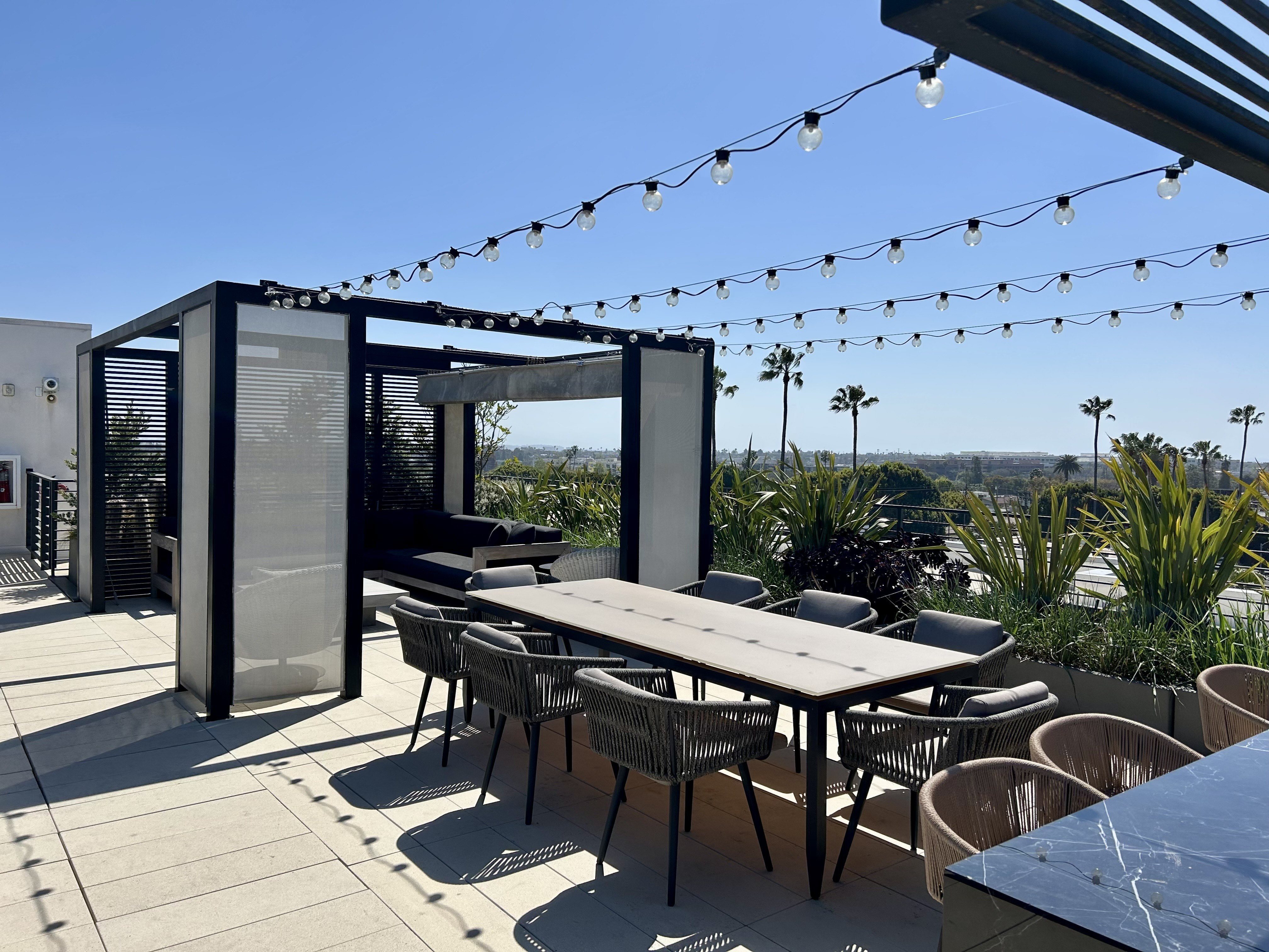 A table with chairs and a canopy is set up on a patio.
