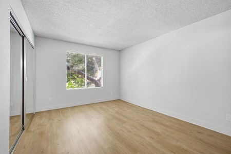 A room with a window and wooden floor.