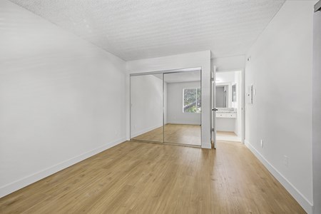 A room with a white wall and wooden floor.