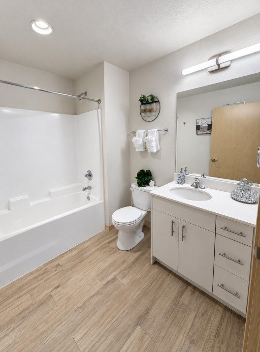 A white bathroom with a toilet, sink, and bathtub.