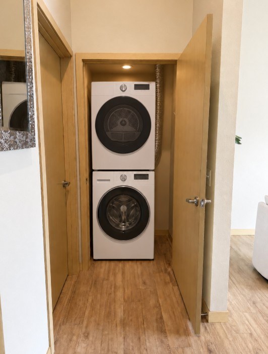 A white dryer is in a small closet.