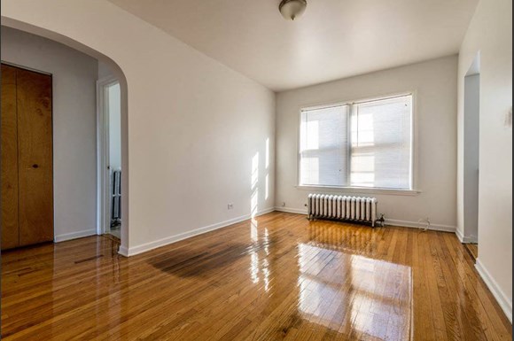 an empty room with wooden floors and a window